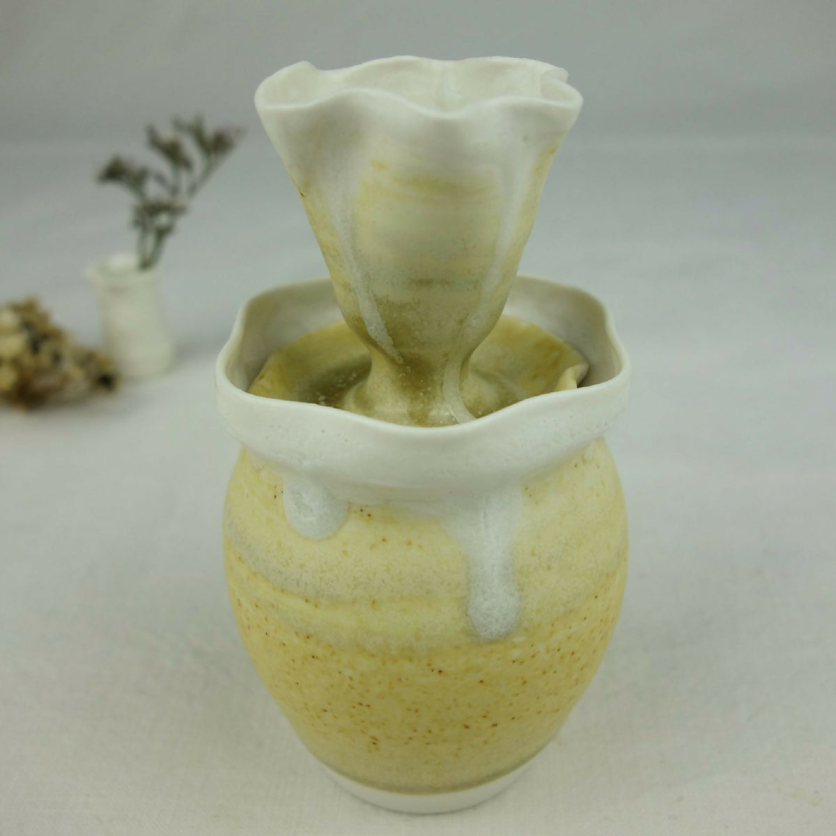 Vase en céramique jaune pâle, col évasé et intérieur vert, motifs au toucher crème