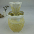 Vase en céramique jaune pâle, col évasé avec texture irrégulière, intérieur vert