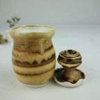 Petit pot en céramique beige et brun, motif marbré, vue de face avec base évasée