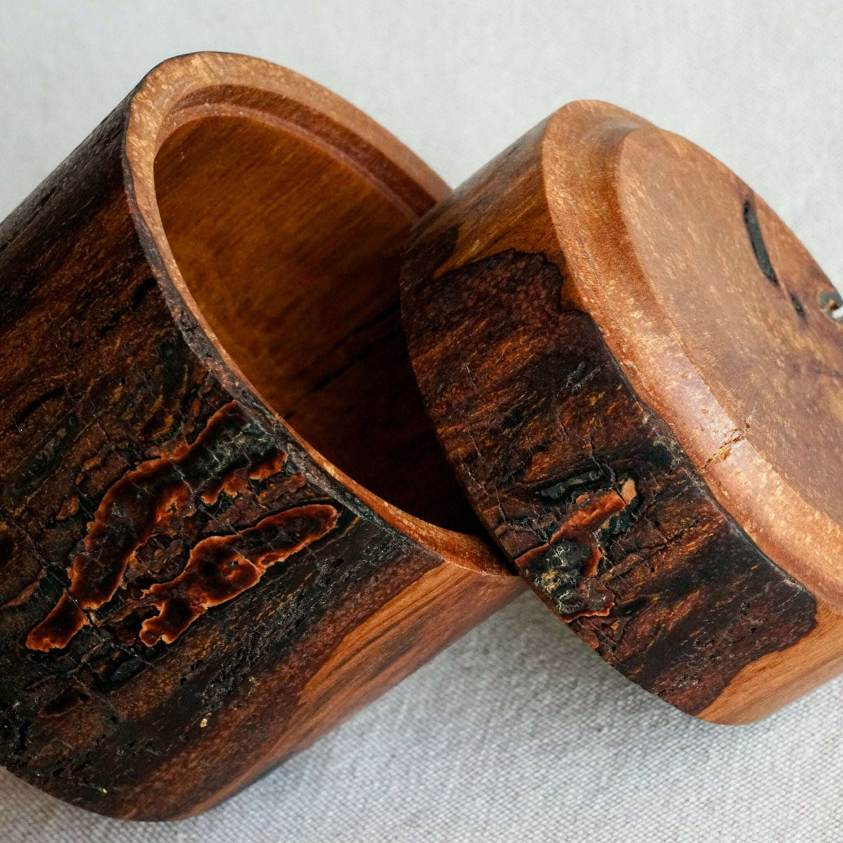 Boîte en bois fait-main avec couvercle ouvert, texture foncée et détails sculptés