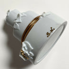 Boîte en porcelaine blanche avec bordure dorée et inscription « S.A. » sur le côté.