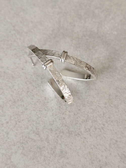 Boucles d’oreilles courbes en métal argenté, intérieur bombé et aspect martelé
