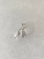 Boucles d’oreilles courbes argentées, fermoirs et côtés texturés bien visibles