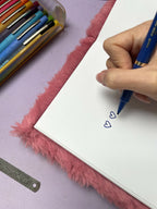 Croquis de boucles d’oreilles cœur bleu sur papier blanc, tracé au stylo bleu