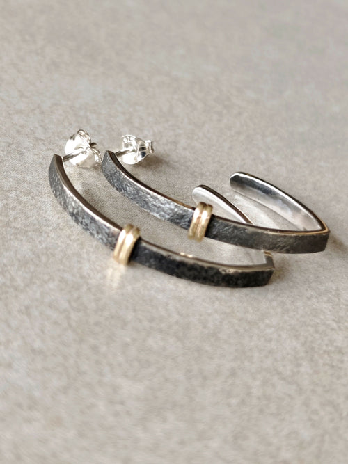 Paire de boucles d’oreilles courbes noires, finitions argentées et attaches dorées