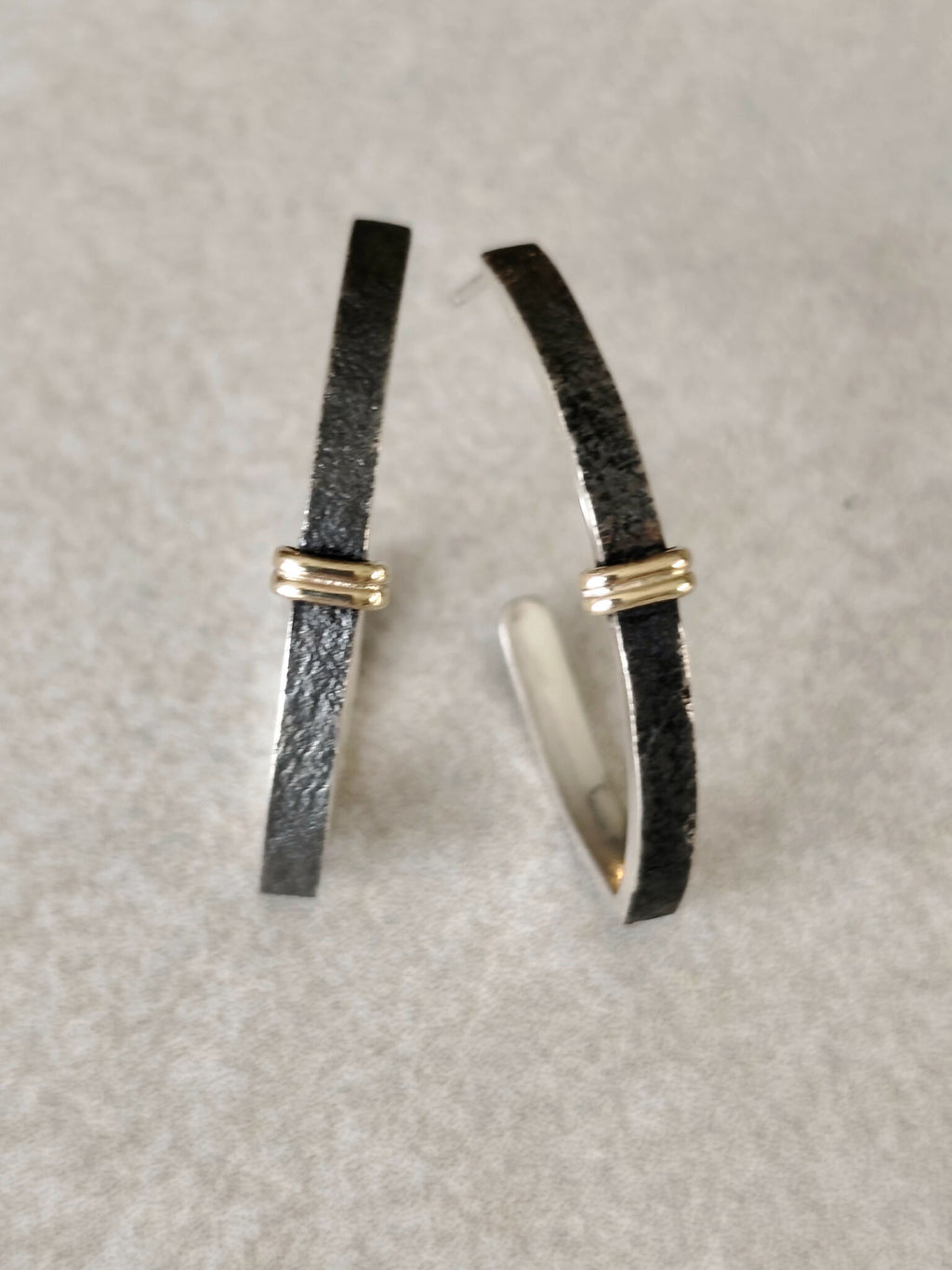 Boucles d’oreilles courbées noires, détails argentés brillants, fermoirs dorés