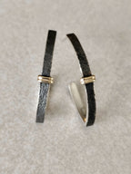 Boucles d’oreilles courbées noires, détails argentés brillants, fermoirs dorés