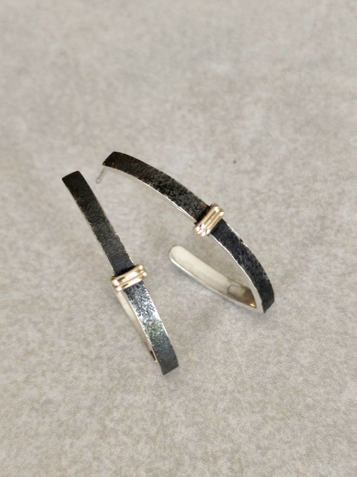 Boucles d’oreilles courbées noires et argentées, attaches dorées verticales