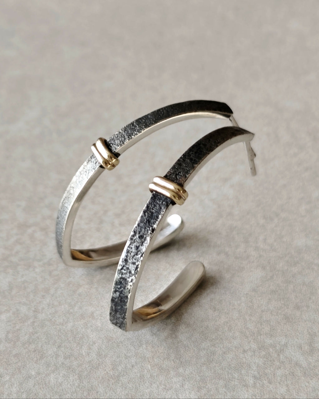 Boucles d’oreilles courbes superposées, base argentée, détails dorés