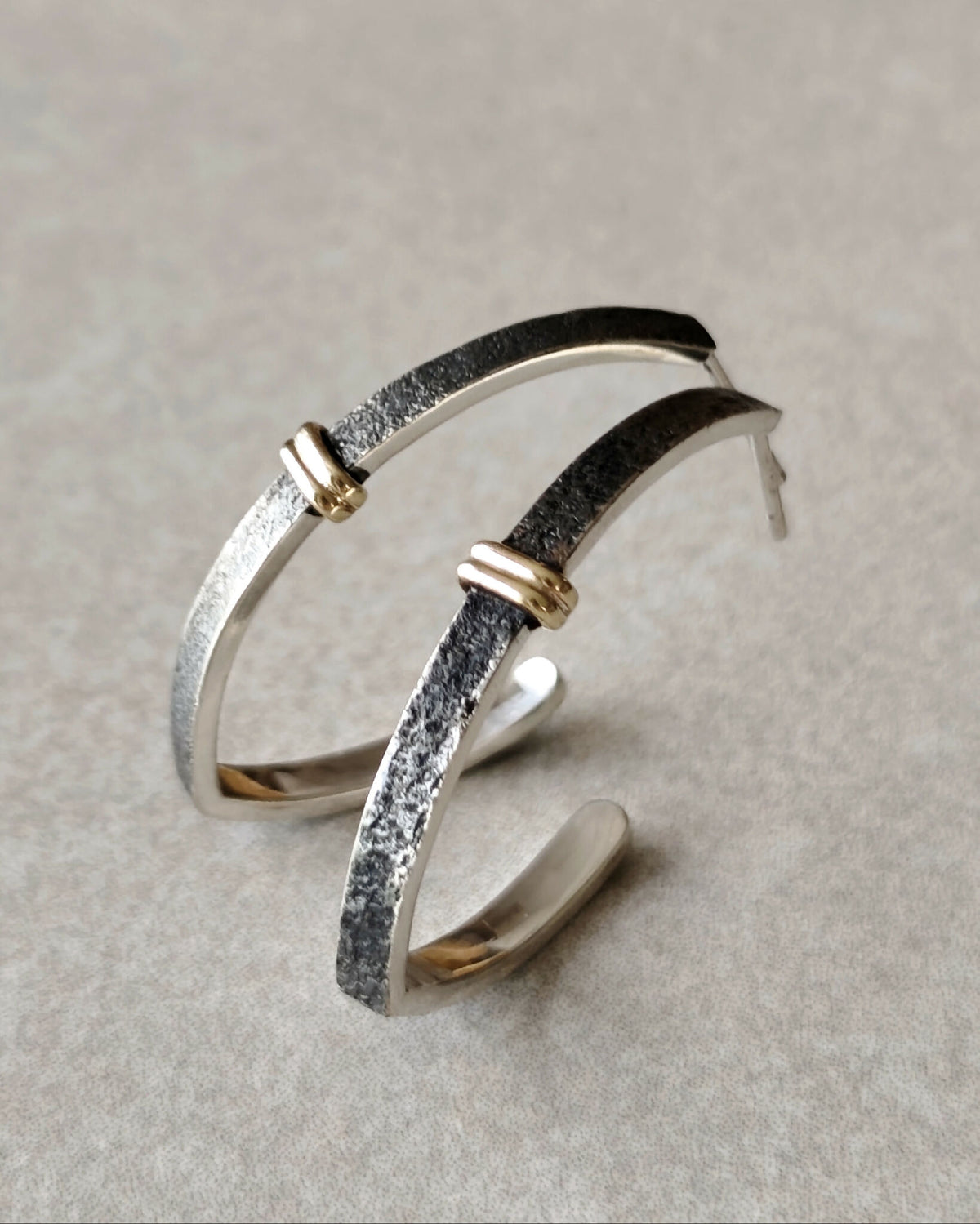 Boucles d’oreilles courbes superposées, base argentée, détails dorés