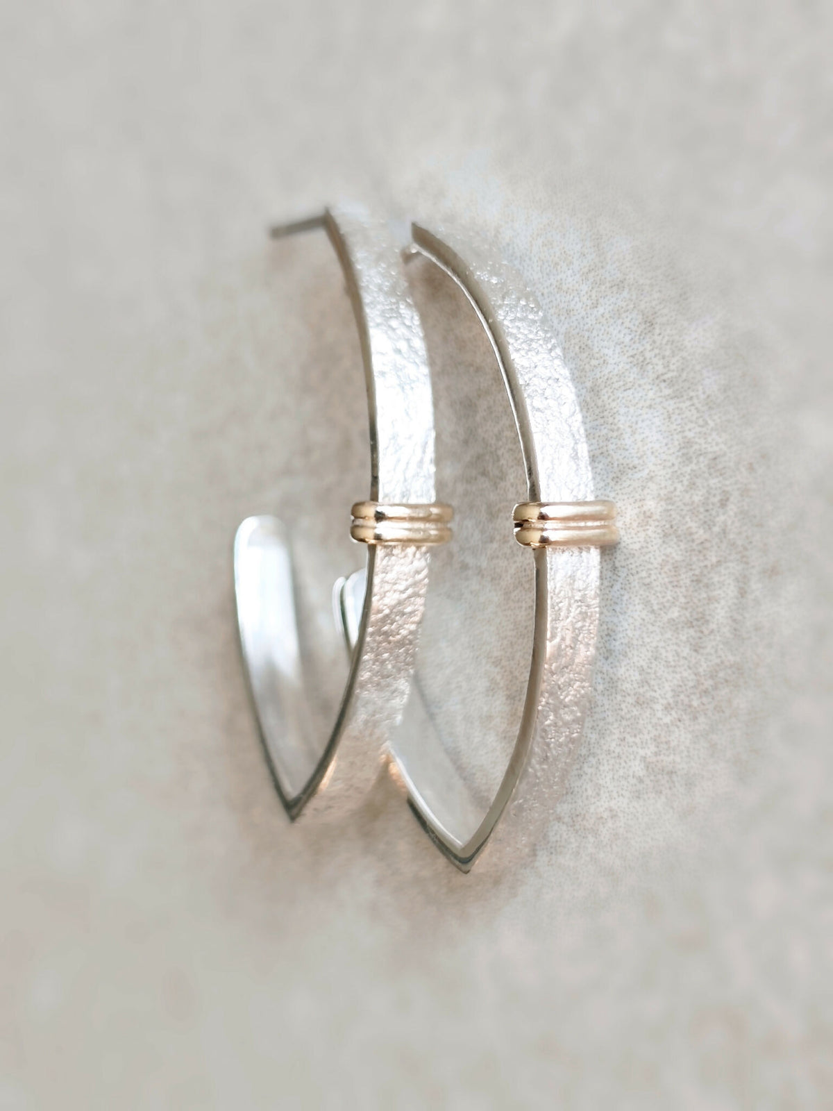 Paire de boucles d’oreilles courbes argentées texturées avec petits anneaux dorés