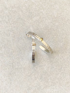 Boucles d’oreilles courbées argent et doré, texture striée, petit point brillant
