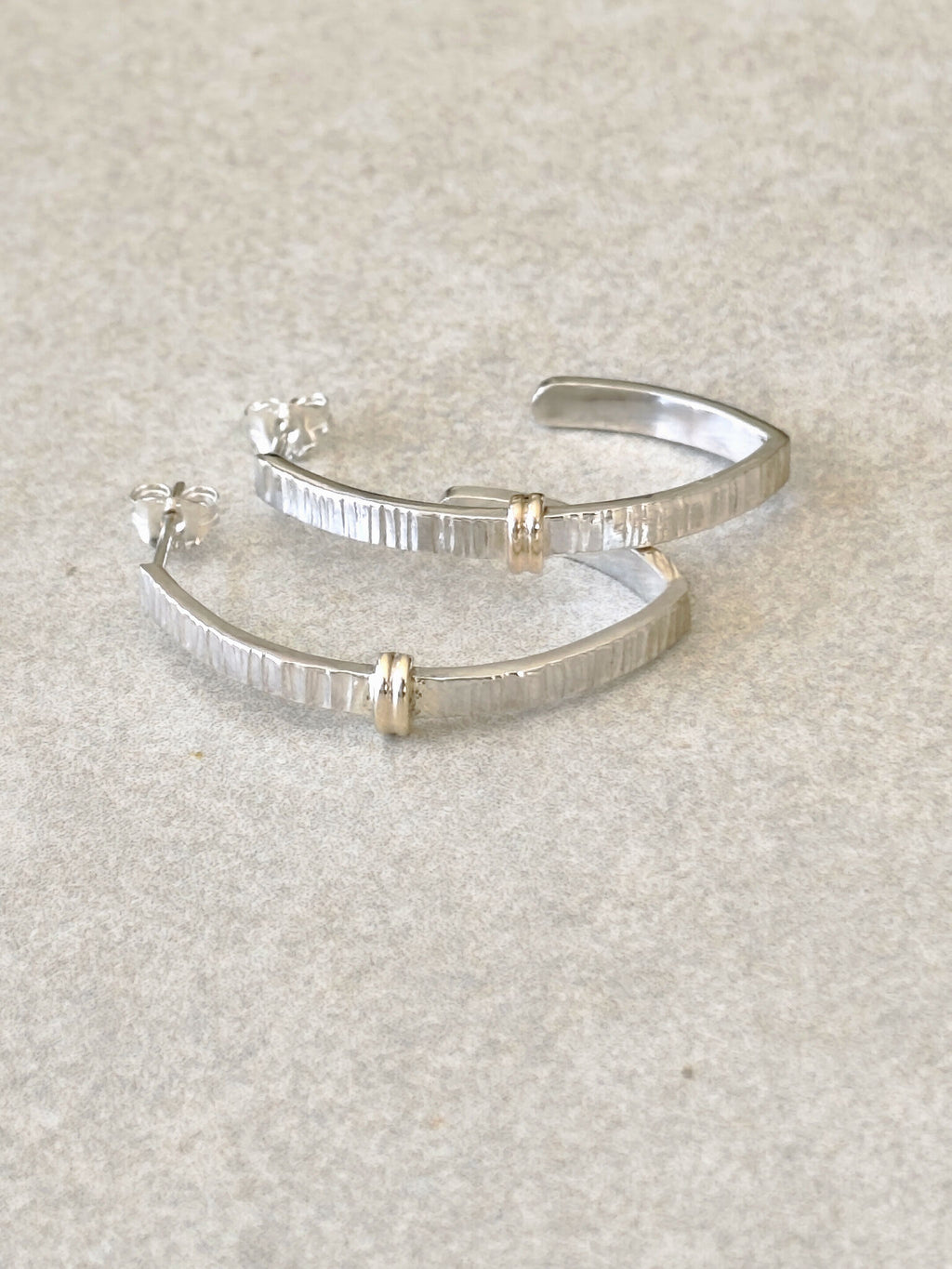 Paire de boucles d’oreilles courbées argentées avec inserts dorés, style rayé