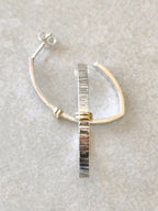 Boucle d’oreille courbée argent strié avec insert doré, tige et petite pointe brillante