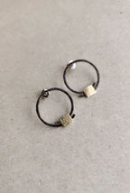 Boucles d’oreilles anneaux noirs, carrés texturés dorés, vue écartée