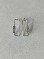 Boucles d’oreilles rectangulaires argentées, rayures verticales sur le centre.