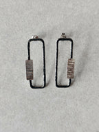 Boucles d’oreilles rectangulaires, plaque striée et bordure foncée, fixation visible
