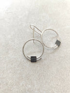 Boucles d’oreilles pendantes: deux anneaux argentés, carré noir en pendentif