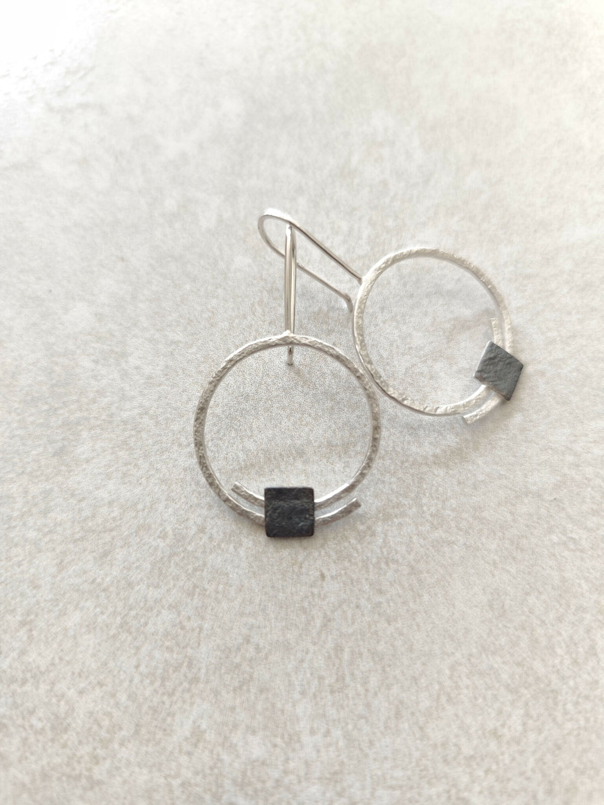 Boucles d’oreilles pendantes: deux anneaux argentés, carré noir en pendentif