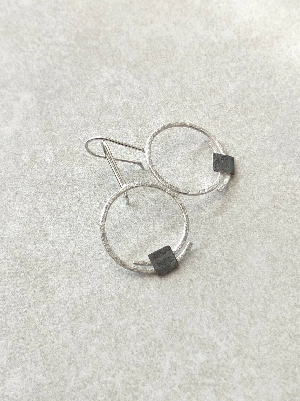 Boucles d’oreilles pendantes anneaux argentés, carrés noirs sur le bas