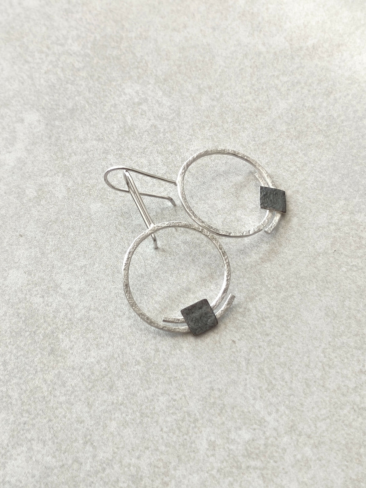 Boucles d’oreilles pendantes anneaux argentés, carrés noirs sur le bas