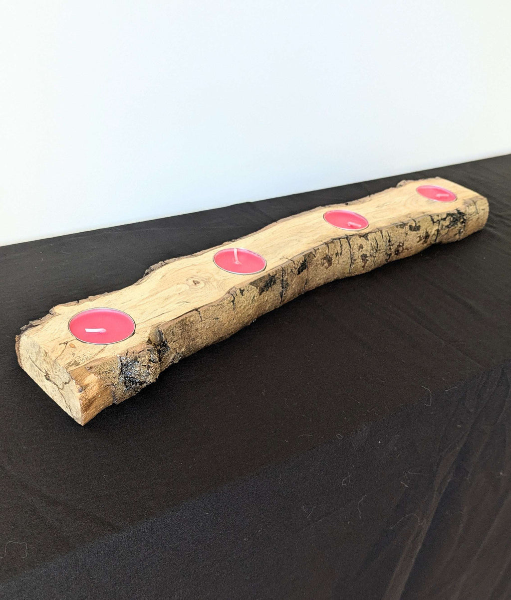 Bougeoir en bois rustique avec 3 bougies roses dans des évidements