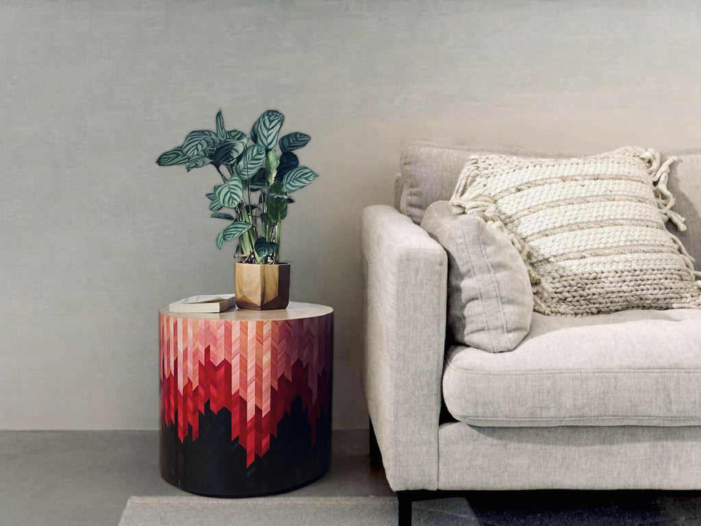 Bout de canapé rond avec motif chevrons rouge et base sombre, dessus beige.