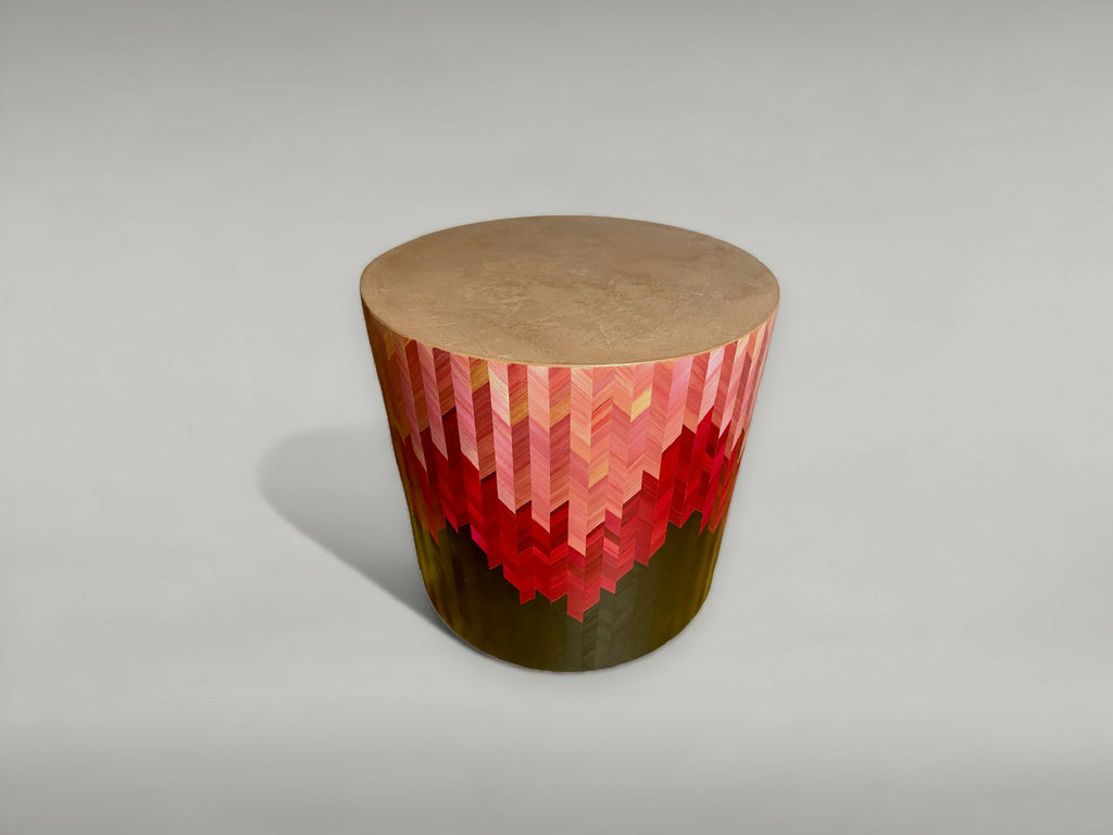 Bout de canapé rond vue en biais : motif chevrons rouge, dessus beige, base sombre.