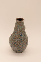 Petite bouteille en céramique bleu-gris à texture granuleuse, goulot brun