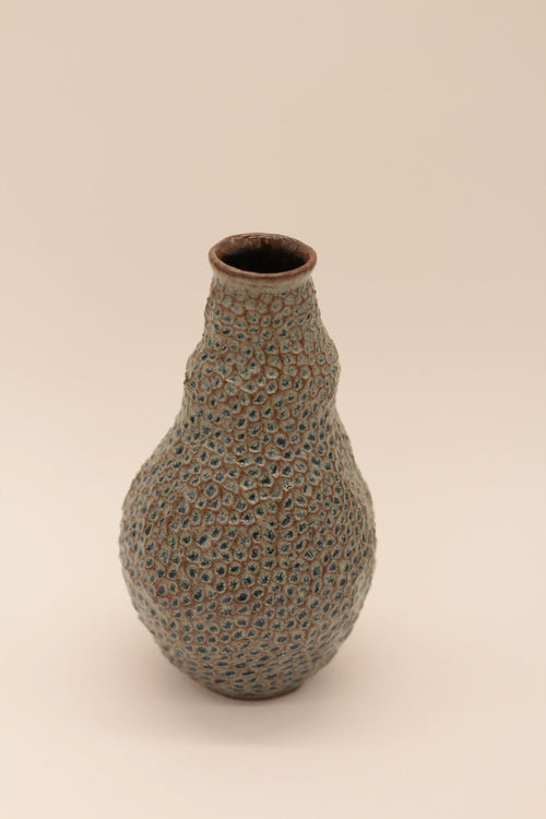 Petite bouteille en céramique bleu-gris à texture granuleuse, goulot brun