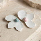 Paire de broches aimantées en porcelaine, fleurs blanches, centres bleu moucheté et rose