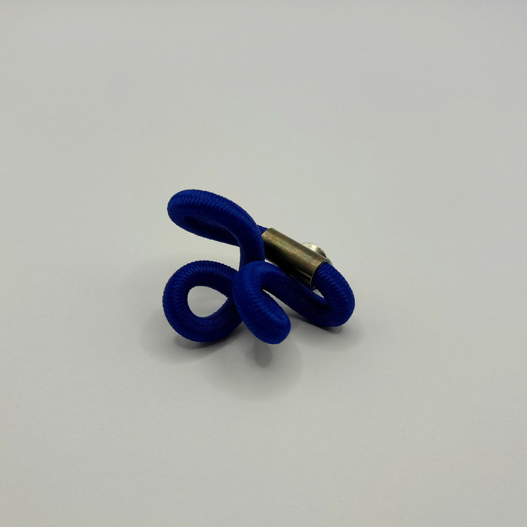 Broche entrelacée bleu avec tige métallique dorée et anneaux texturés.