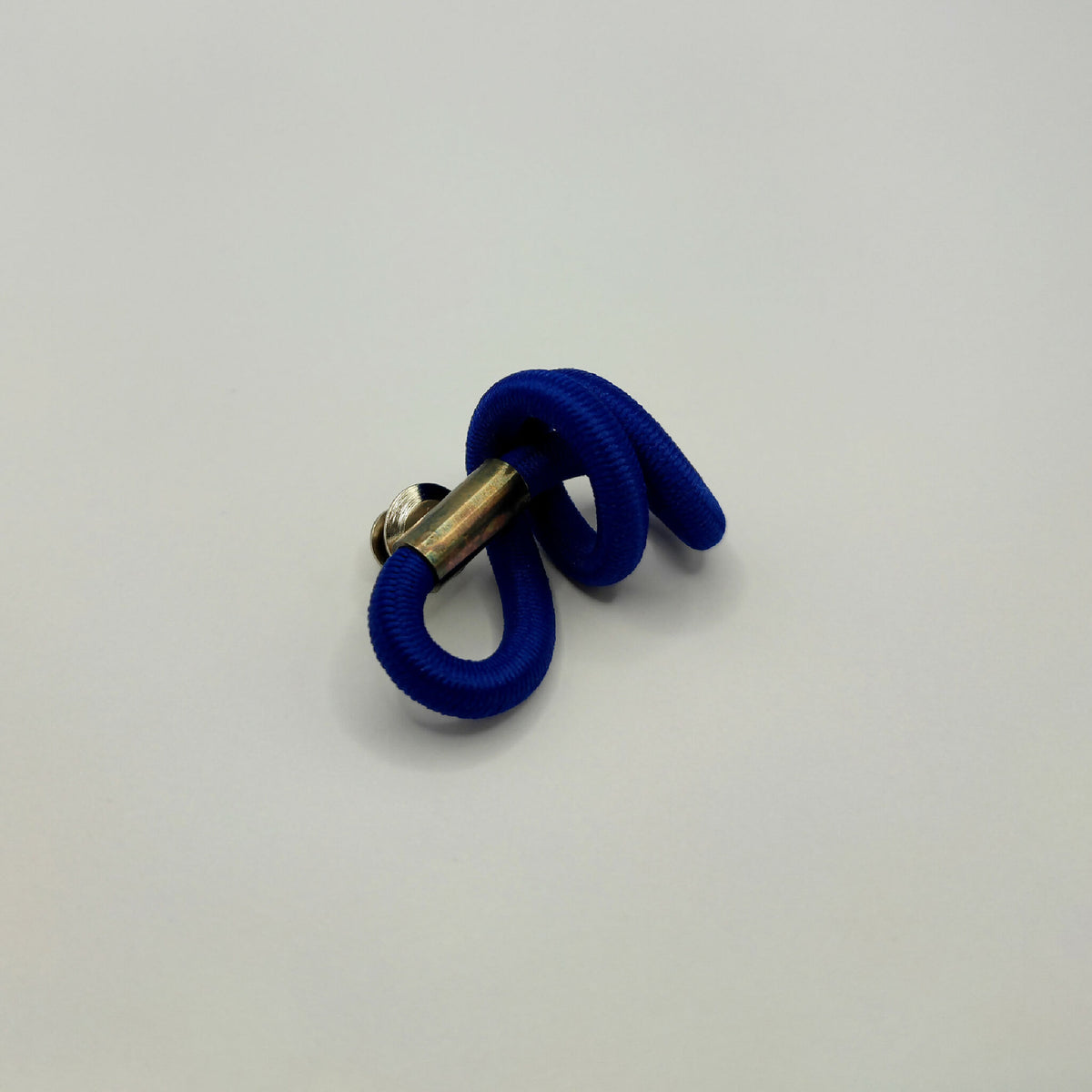 Broche en tissu bleu noué avec tige métallique dorée et boucles.