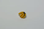 Broche entrelacée jaune, fermoir noir visible, vue rapprochée.