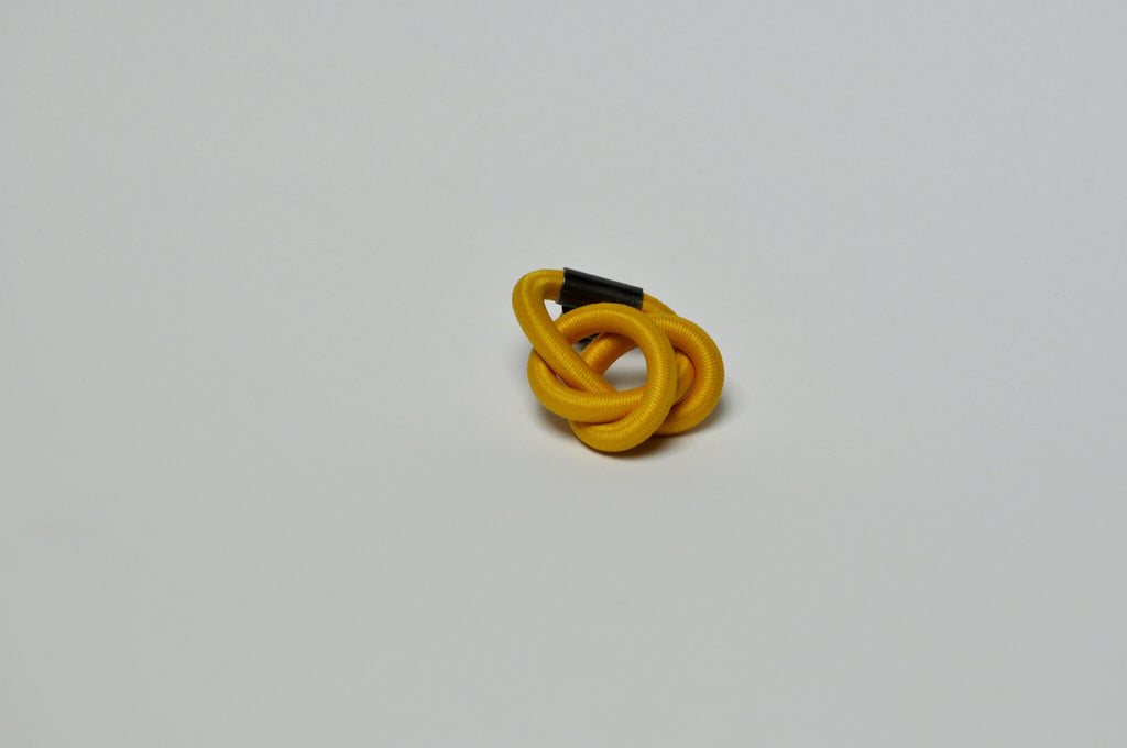 Broche entrelacée jaune, nœud de boucles concentriques.