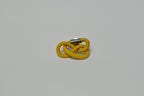 Broche entrelacée jaune avec tige métallique, vue latérale.