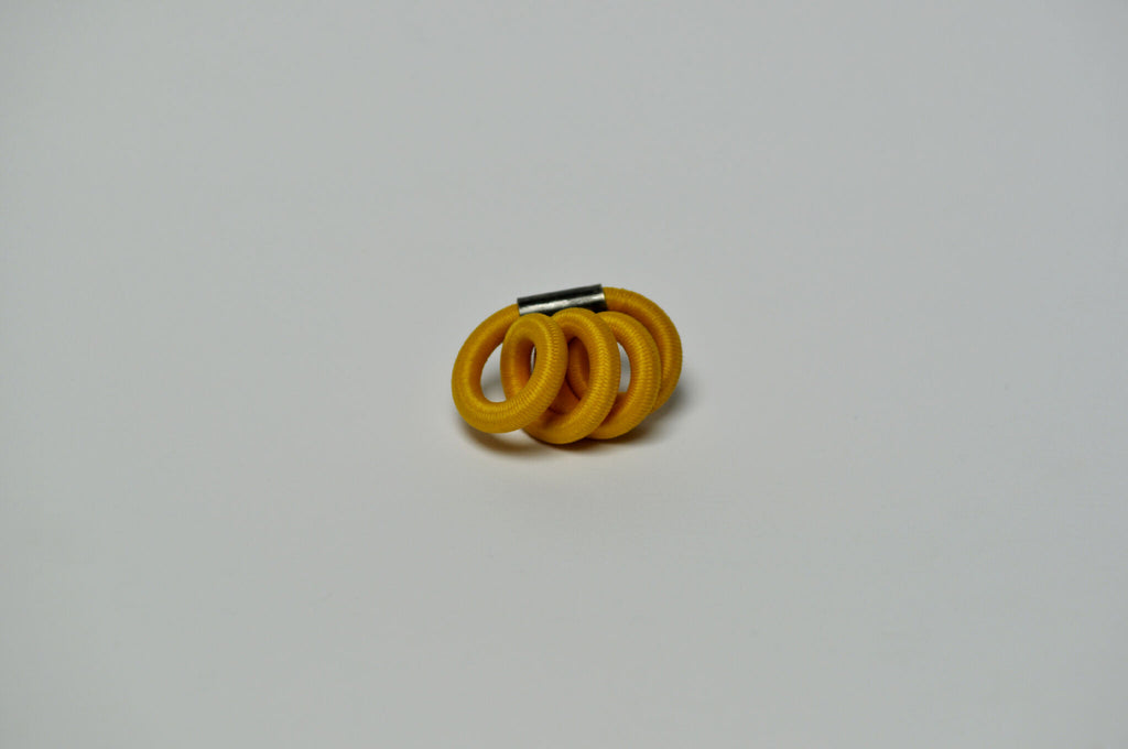 Broche entrelacée jaune, arrière avec tige/attache métallique.