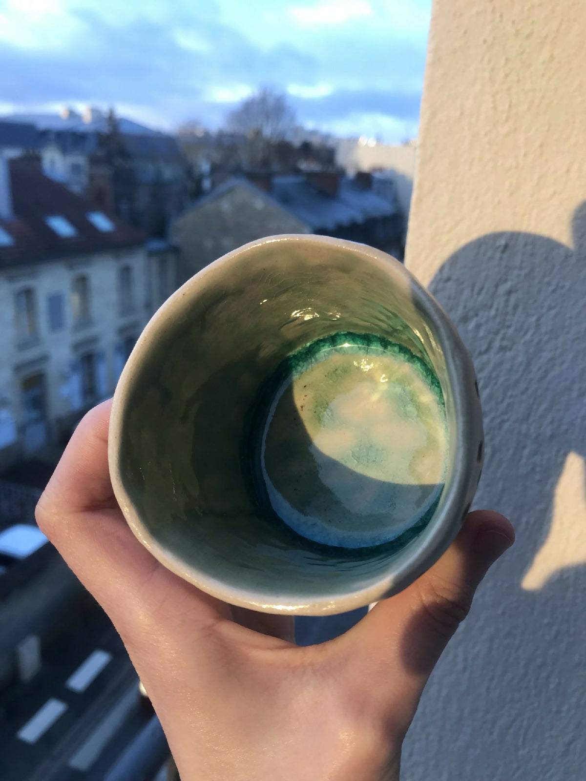 Intérieur du cache-pot en céramique émaillée bleu-vert, base arrondie.