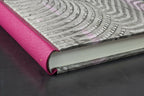 Reliure en cuir fuchsia et tranche du cahier, motifs ondulés sur la couverture.