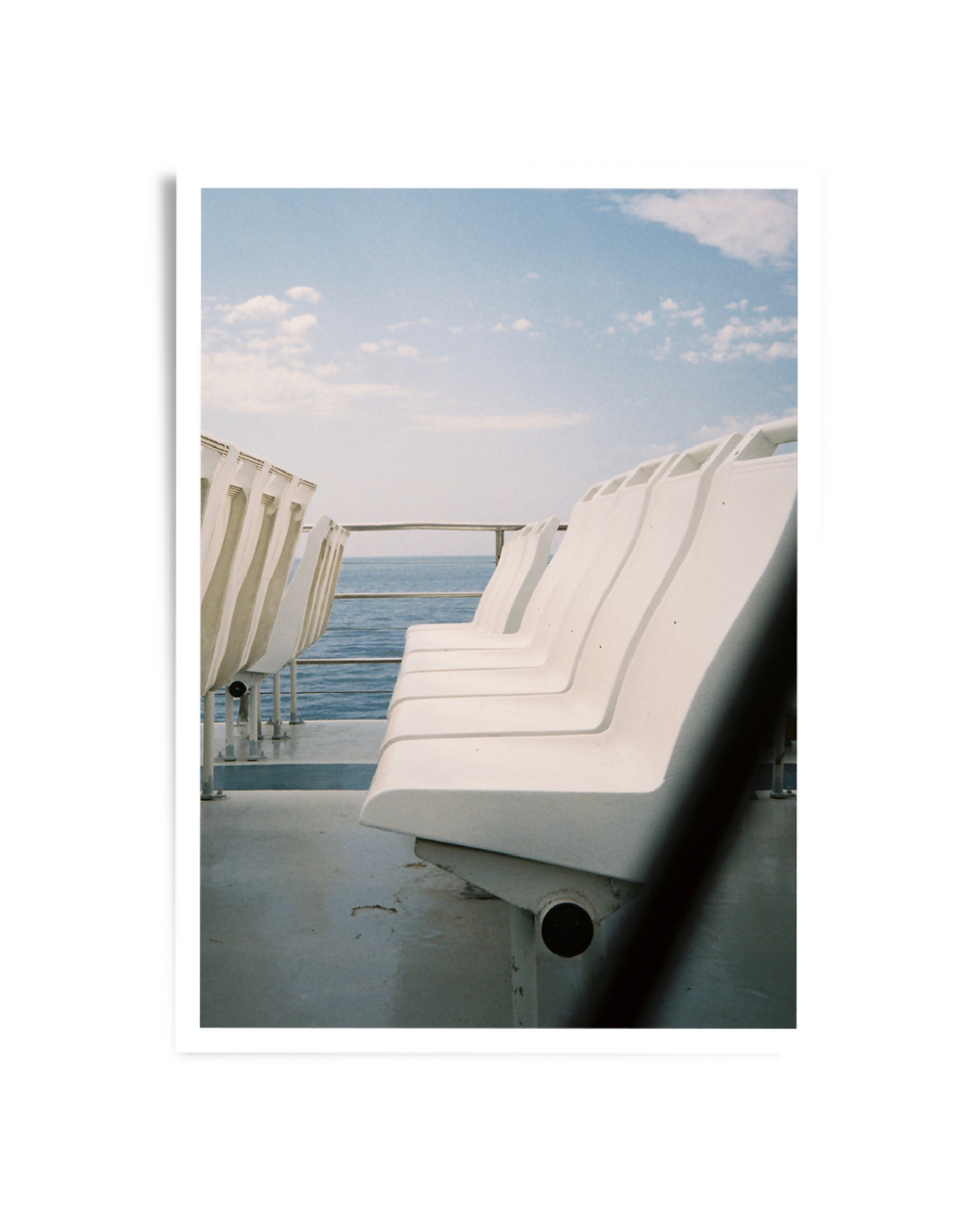 Photo encadrée montrant des chaises longues blanches face à la mer