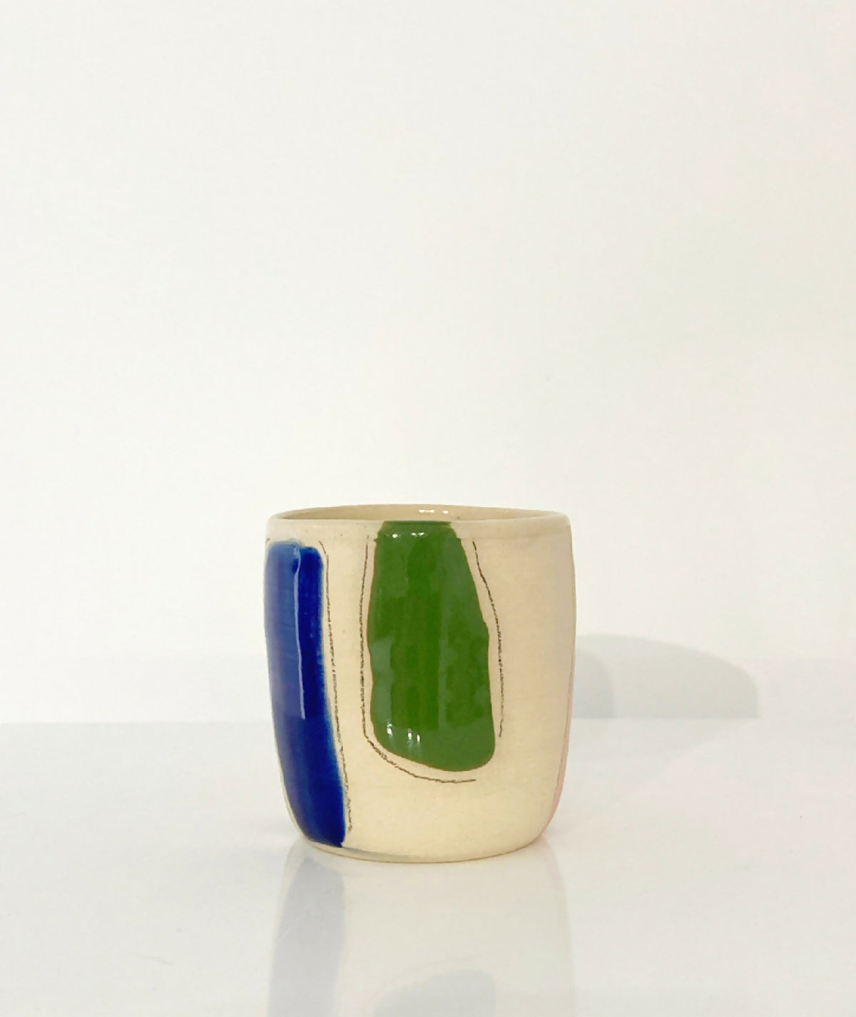 Gobelet en céramique beige avec motif vert et bande bleue