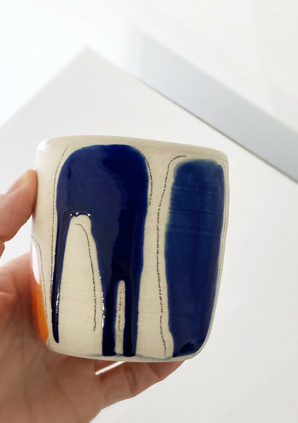 Gobelet en céramique beige, motifs bleu nuit et touche orange