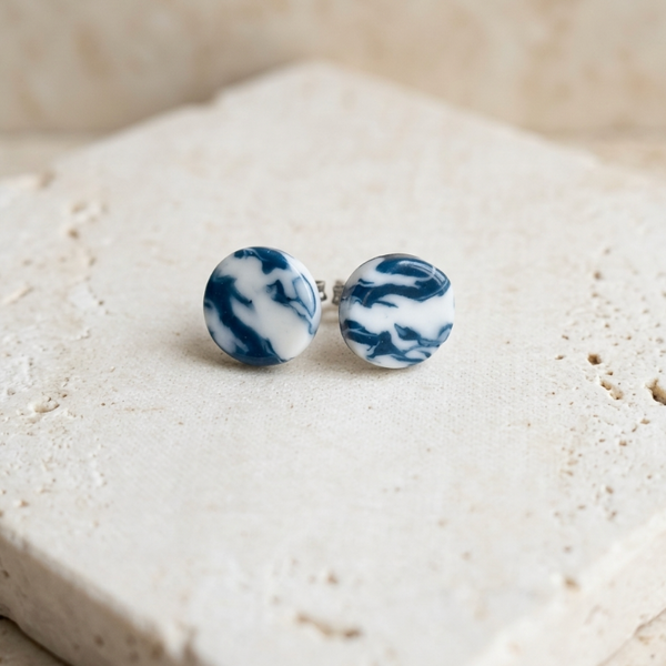 Clous d’oreille en porcelaine bleue motif marbré, paire sur socle clair
