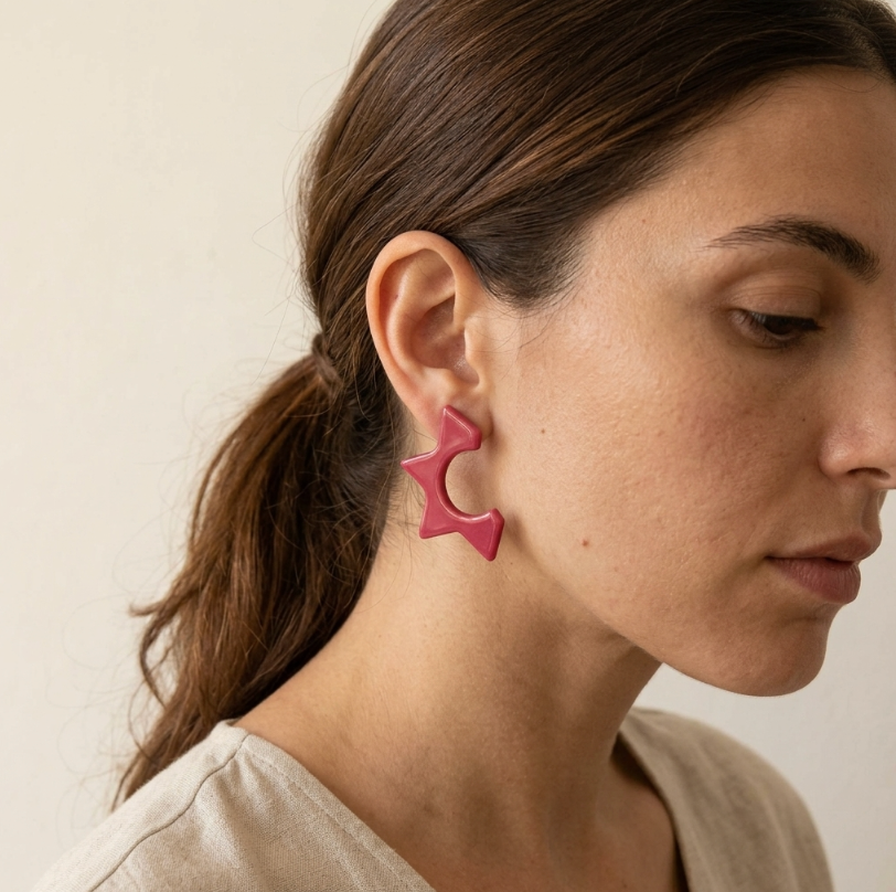 Boucles d’oreille clous étoile en porcelaine rouge, portées sur l’oreille