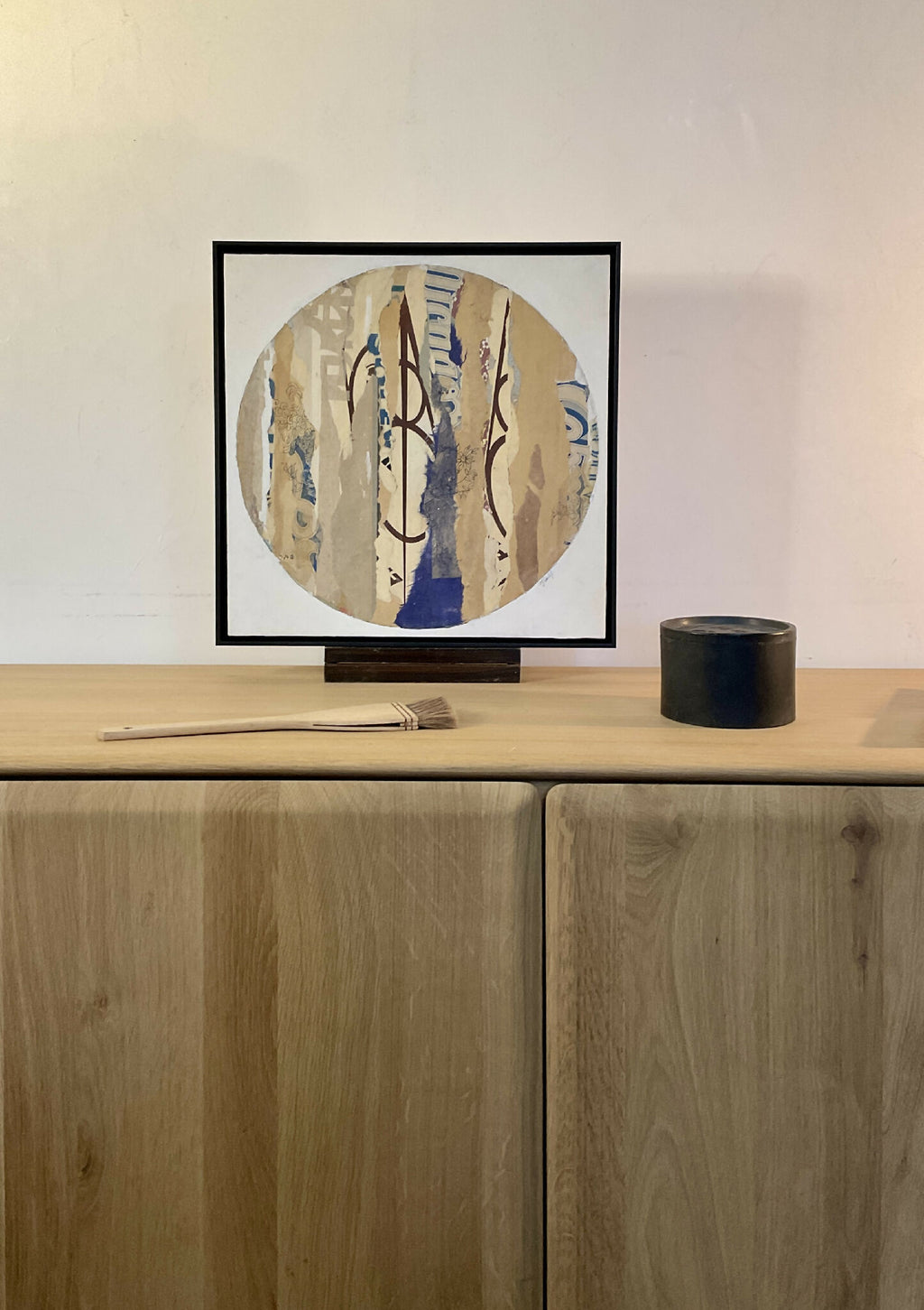 Collage sur bois ARGILE dans cadre noir, composition circulaire abstraite bleu et beige.