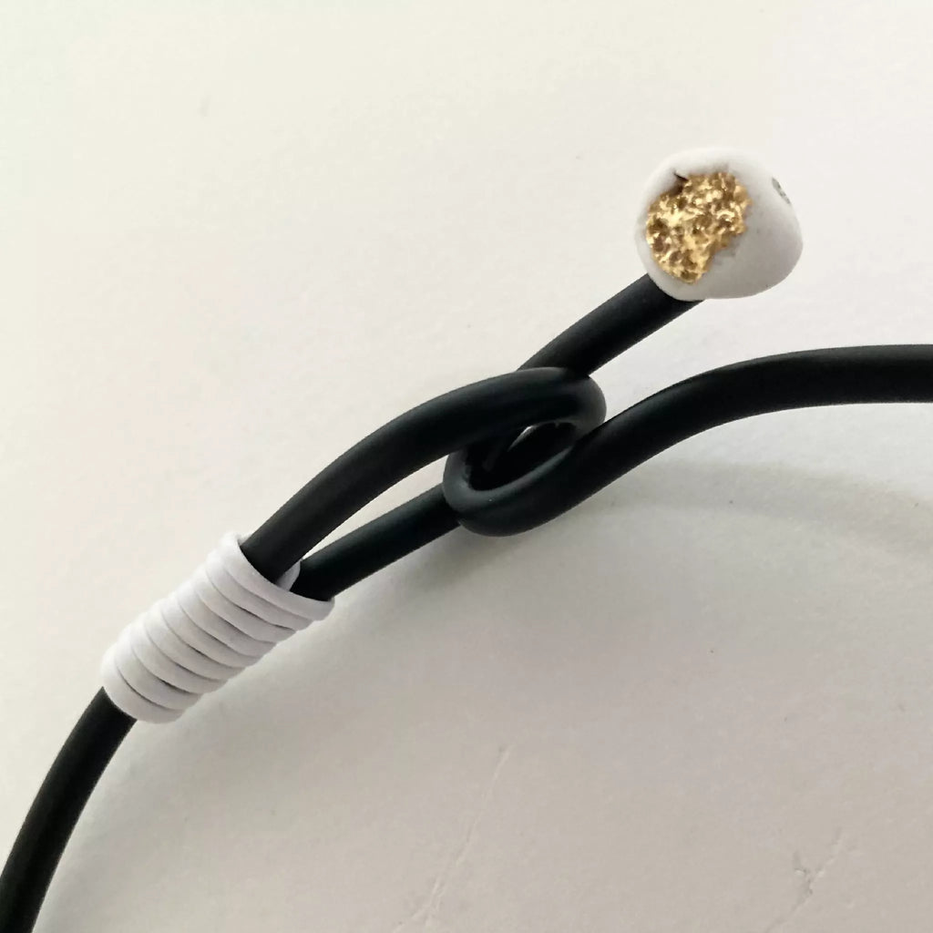 Bracelet, cordon noir avec pastille dorée au bout