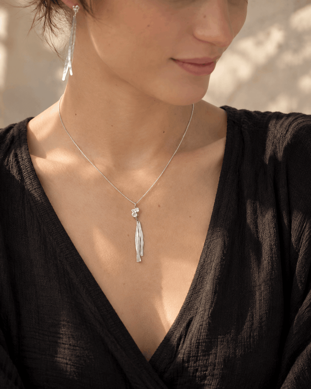 Collier en argent porté, pendentif à pampilles au centre sur chaîne fine.