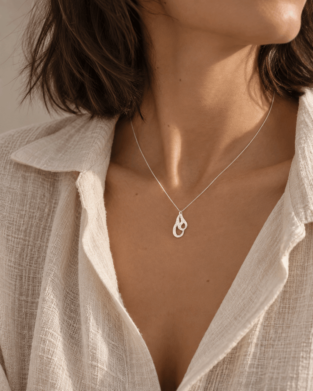Collier en argent massif à pendentif goutte sur chaîne fine, porté près du cou