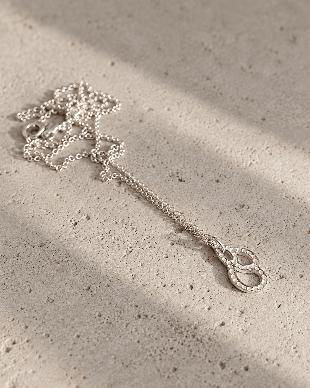 Collier en argent massif à pendentif goutte et chaîne fine, fermoir et maillons visibles