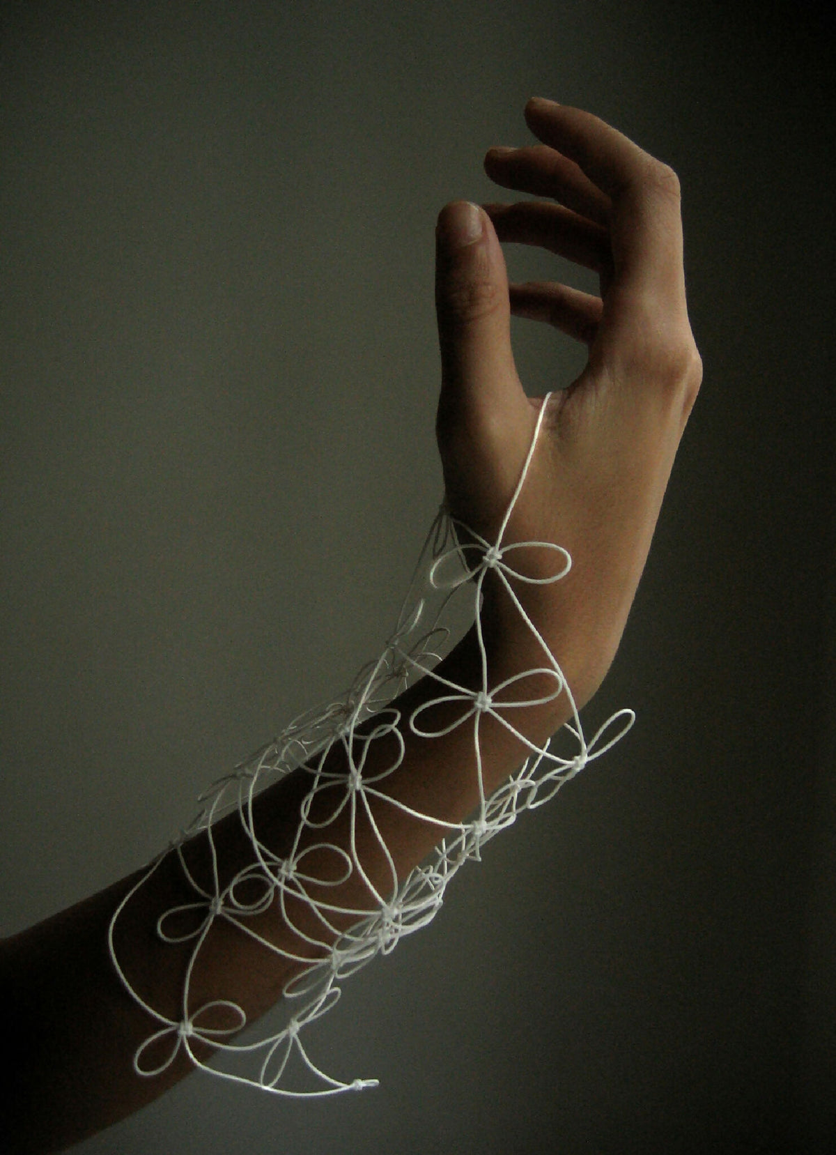 Bracelet en fil blanc fin, motifs bouclés et perles